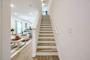A staircase in a home with a white wall on the side.