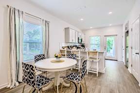 A dining room with a white table and chairs.