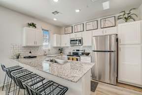 A kitchen with a granite countertop and stainless steel appliances.