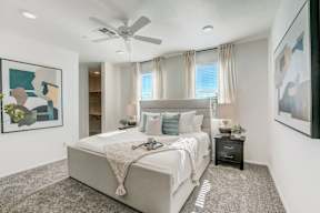 A bedroom with a large bed and a ceiling fan.