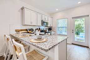 A kitchen with a granite countertop and white cabinets.