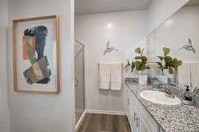 A bathroom with a large painting on the wall.