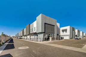 A row of modern buildings with a clear blue sky above.