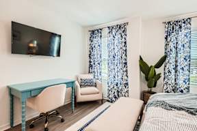 A bedroom with a bed, desk, and chair.