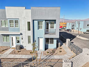 A modern two story house with a blue door and window.