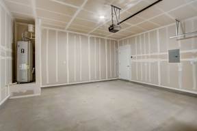 A room under construction with a white ceiling and walls, and a furnace on the left.