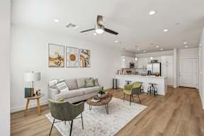 A living room with a couch, chairs, and a rug.