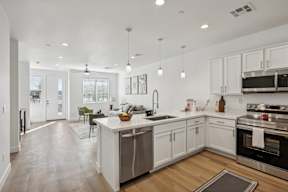 A modern kitchen with white cabinets and stainless steel appliances.