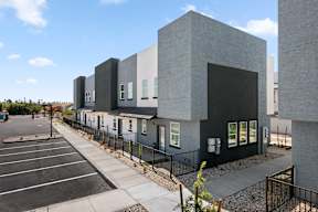 A modern building with a parking lot in front.
