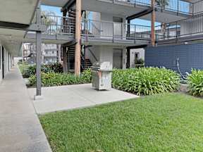 A concrete walkway leads to a bbq grill