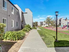 A residential area with a sidewalk and a playground.