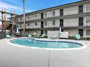 A swimming pool in front of a multi-story apartment building.