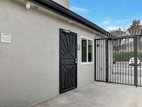 A black gate is closed next to a laundry room