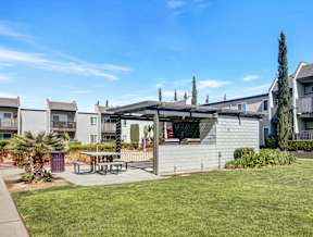 A sunny day at a residential area with apartment buildings and a picnic table.