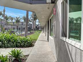 A long concrete walkway with a red sign on the wall.