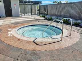 A hot tub sits inside the gated pool