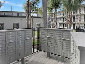 A metal mailbox is on the left and right side of a gate.