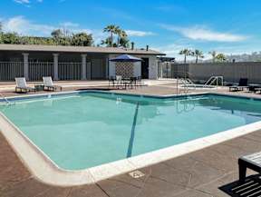 A swimming pool with a table and chairs.