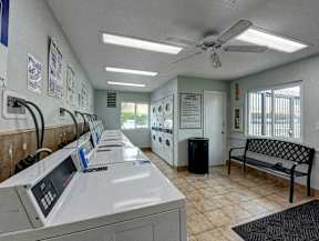 A row of washing machines are lined up in a laundromat.