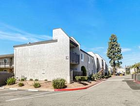 A row of modern apartment buildings with a clear blue sky above.