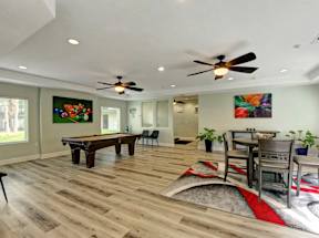 A room with a pool table and a painting on the wall.