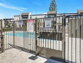 A pool area is gated off with a sign that says Please keep gate closed