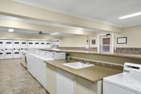 Laundry Facility at El Dorado with washers and dryers and a sink