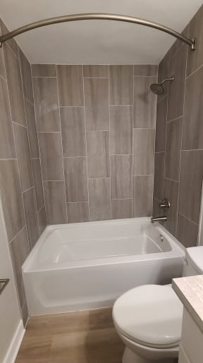 a small bathroom with a toilet and a bath tub