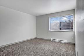 an empty bedroom with a large window