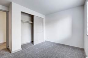 a bedroom with white walls and a closet with a white door