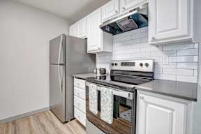 a kitchen with a stove top oven next to a refrigerator