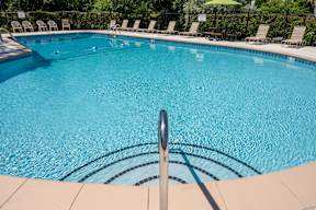 A swimming pool with a metal pole in the middle.