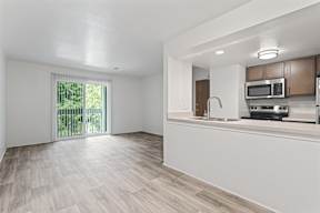 A kitchen area with a microwave, oven, and sink.