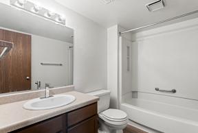A bathroom with a white sink, toilet, and bathtub.