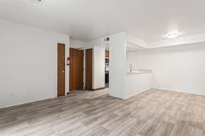 A room with a white wall and a wooden floor.