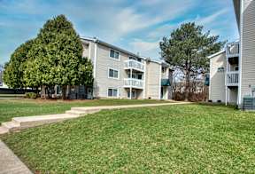 A grassy area in front of apartment buildings.