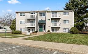 Apartment building with a green lawn in front.