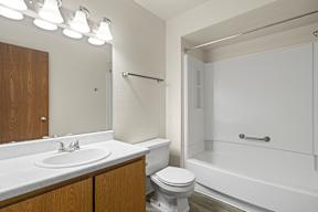 A white bathroom with a toilet, sink, and bathtub.
