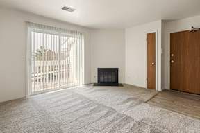 A room with a fireplace and sliding glass doors.