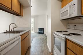A kitchen with white appliances and wooden cabinets.