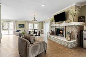 A living room with a fireplace and a television on the wall.