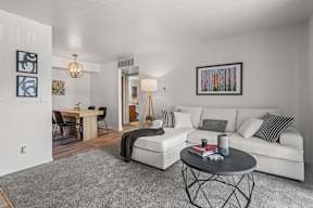A living room with a white couch and a coffee table.