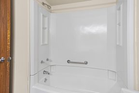 A white bathroom with a tub and shower.