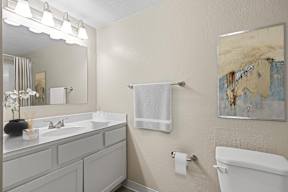 A bathroom with a white towel hanging on the towel rack.