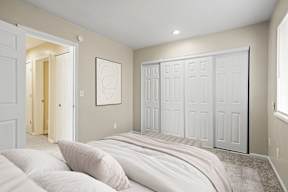 A bedroom with a large bed and a white door.
