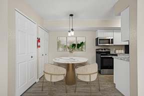 A modern kitchen with a dining table set for two.