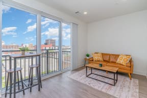 a living room with a couch and a table on a balcony  at City View Apartments, Lansing