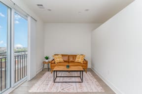 a living room with a couch and a coffee table and a balcony at City View Apartments, Lansing, Michigan