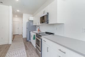 a renovated kitchen with white cabinets and stainless steel appliances  at City View Apartments, Lansing