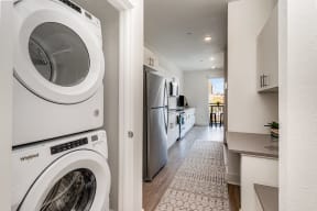 an empty laundry room with a washing machine and a washer and dryer at City View Apartments, Lansing, MI